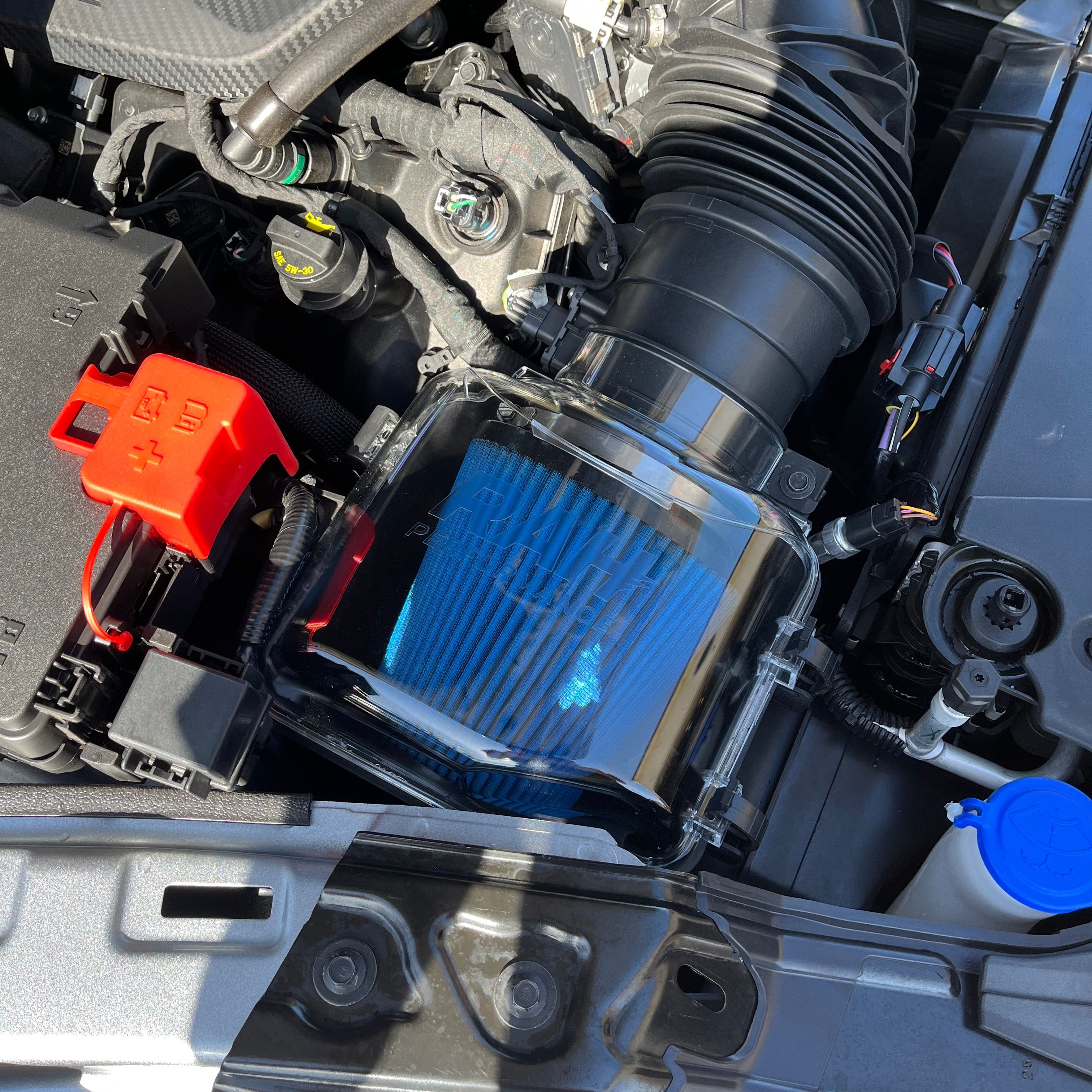 Close-up of a car engine with a blue air filter.