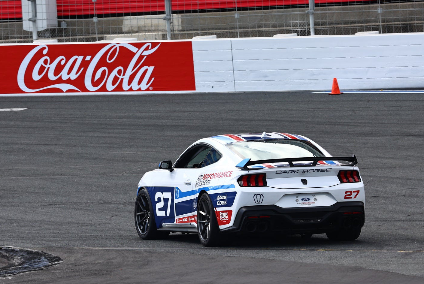 Race car on a track with Coca-Cola branding in the background